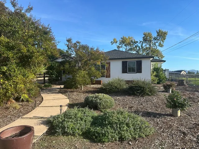 a view of a backyard with plants and a patio