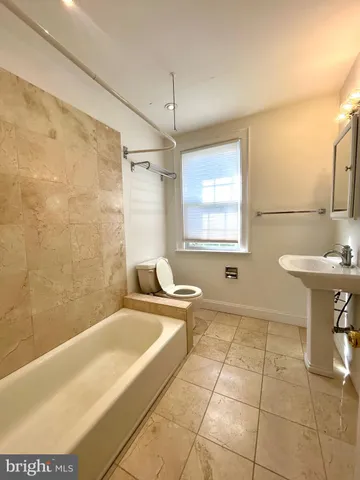 a bathroom with a sink a bathtub and a window