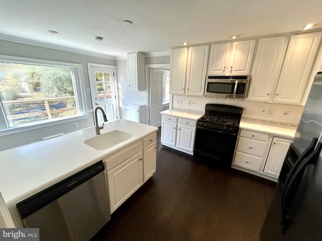 a kitchen with a sink stove top oven and refrigerator