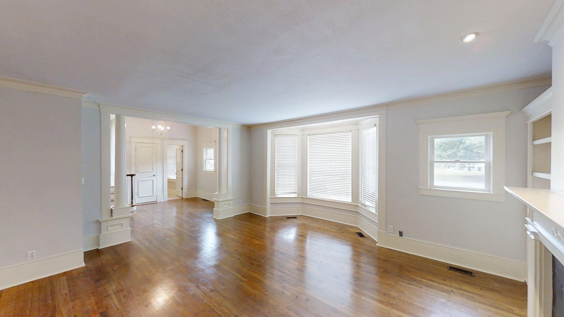 219 F Street Southwest Ardmore, OK 73401 - Photo 8 of 58 Hardwood flooring, bay window, white mantel, built-in shelving, and recessed lighting