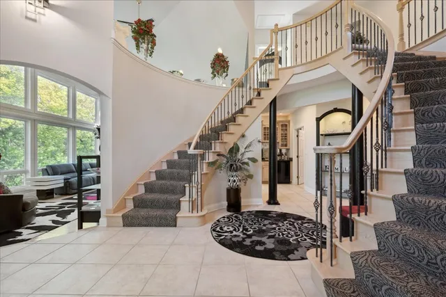 a kitchen with stainless steel appliances granite countertop a refrigerator a sink dishwasher a oven and white cabinets next to a window