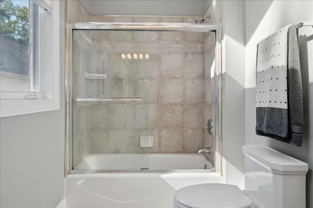 a view of a white house next to a yard with wooden fence