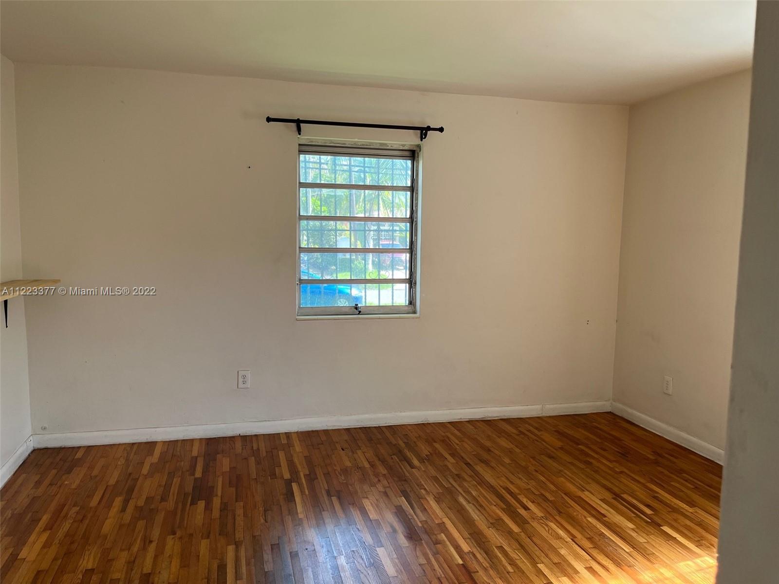 Miami-Dade County Miami, FL 33161 - Photo 5 of 10 an empty room with wooden floor and windows
