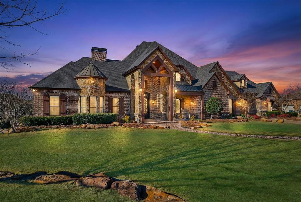 View of front of home with a standing seam roof, a yard, a metal roof, and a chimney