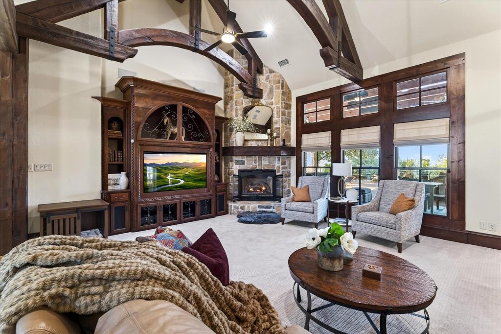 1625 Timber Ridge Trail Cross Roads, TX 76227 - Photo 11 of 40 Living room with high vaulted ceiling, a stone fireplace, beamed ceiling, and carpet