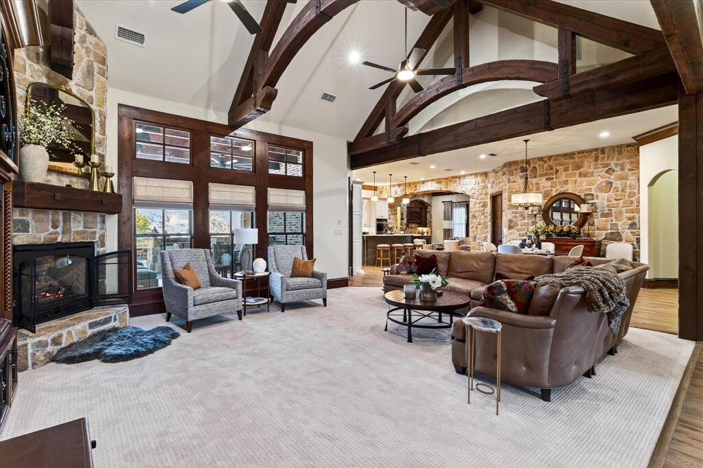 1625 Timber Ridge Trail Cross Roads, TX 76227 - Photo 12 of 40 Living room with high vaulted ceiling, arched walkways, ceiling fan, a fireplace, and a chandelier