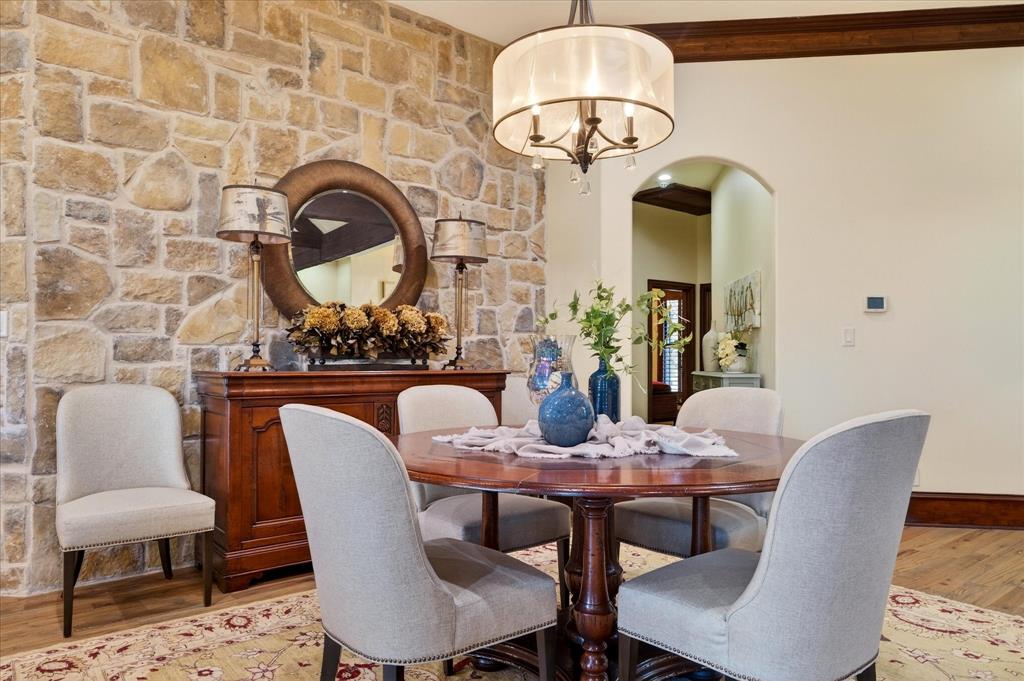 1625 Timber Ridge Trail Cross Roads, TX 76227 - Photo 15 of 40 Dining space featuring wood finished floors, a chandelier, and arched walkways
