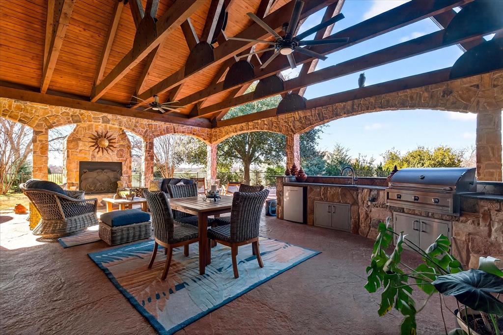 1625 Timber Ridge Trail Cross Roads, TX 76227 - Photo 40 of 40 View of patio featuring a ceiling fan, an outdoor stone fireplace, an outdoor kitchen, and outdoor dining space