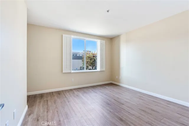 an empty room with wooden floor and window