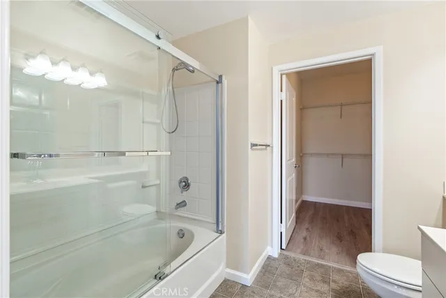 a bathroom with a tub shower sink vanity and a toilet
