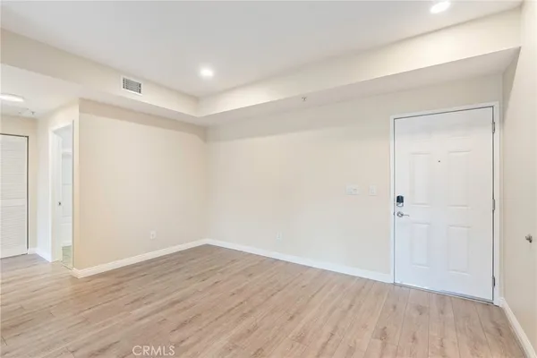 a view of an empty room with wooden floor