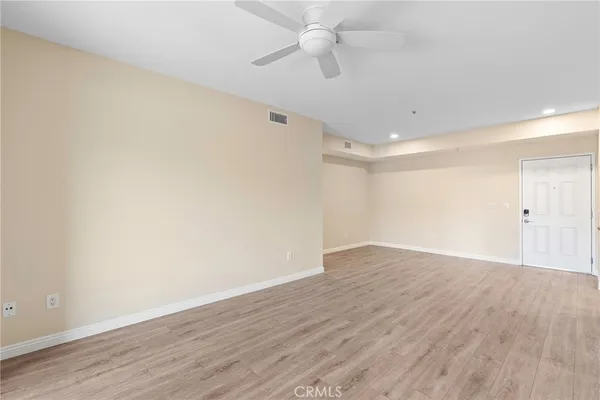 a view of an empty room with wooden floor