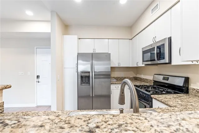 a kitchen with a refrigerator and a stove top oven