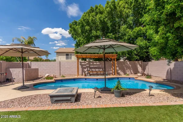 a view of a backyard with a table and chairs under an umbrella