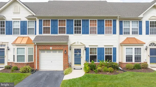 front view of a brick house with a yard