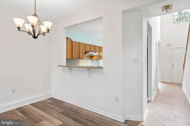 a view of a room with wooden floor and chandelier