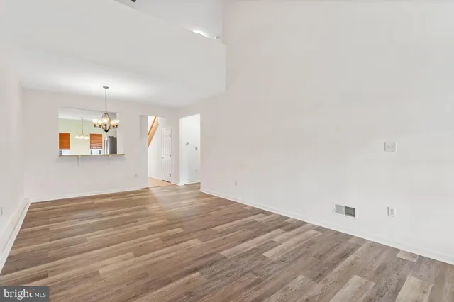 a view of a room with wooden floor and white walls