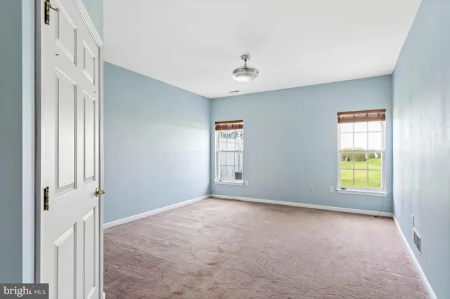 an empty room with windows and cabinet