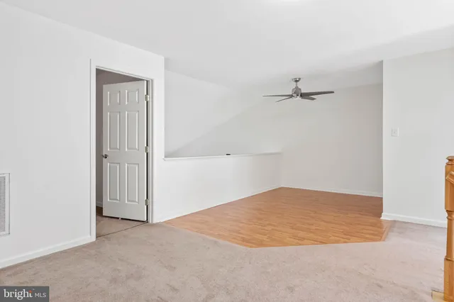 an empty room with closet and chandelier fan