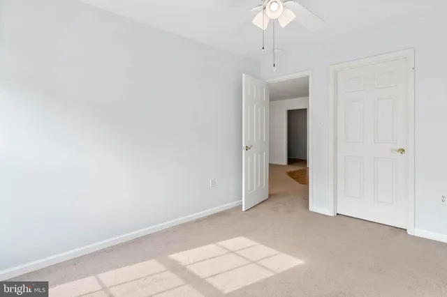 a view of an empty room with a chandelier fan