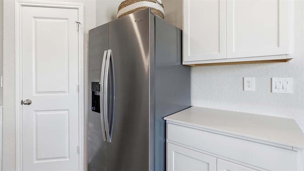226 Pheasant Run Road Terrell, TX 75160 - Photo 28 of 36 Stainless steel side-by-side refrigerator, white flat-panel cabinetry, and a light-colored countertop