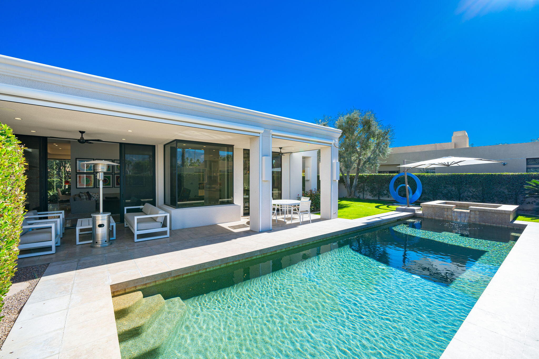 6 Sun Ridge Circle Rancho Mirage, CA 92270 - Photo 12 of 56 a view of a swimming pool with lawn chairs and floor to ceiling window