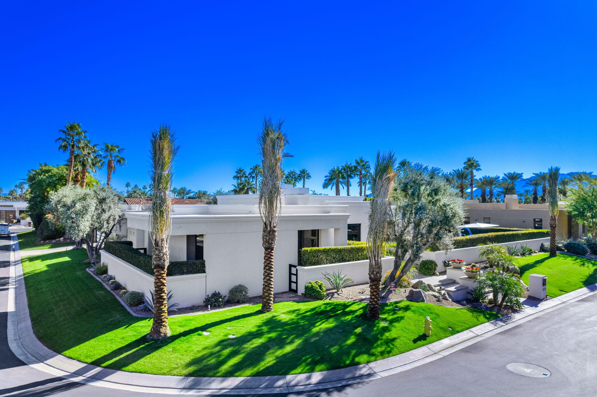 6 Sun Ridge Circle Rancho Mirage, CA 92270 - Photo 3 of 56 a front view of a house with a yard and potted plants