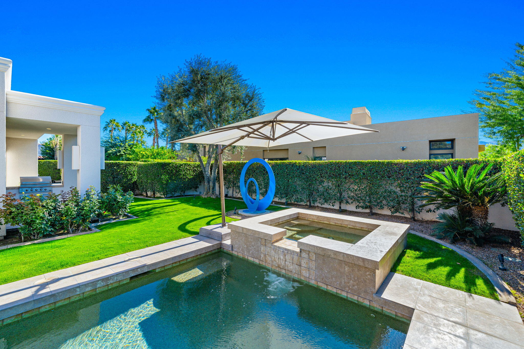 6 Sun Ridge Circle Rancho Mirage, CA 92270 - Photo 50 of 56 a view of a patio with a table and chairs under an umbrella