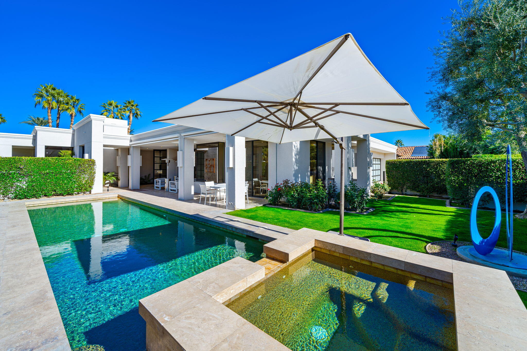 6 Sun Ridge Circle Rancho Mirage, CA 92270 - Photo 51 of 56 a view of a house with a swimming pool and a yard