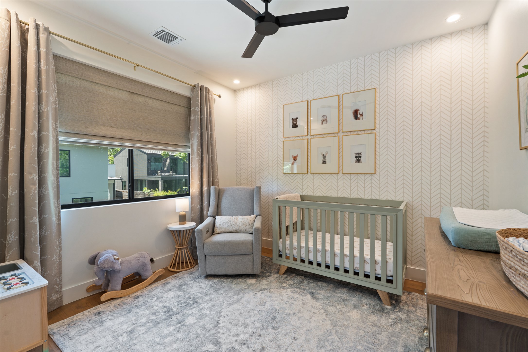 2107 Peach Tree Street Austin, TX 78704 - Photo 27 of 40 Bedroom featuring a crib, baseboards, ceiling fan, and wood finished floors