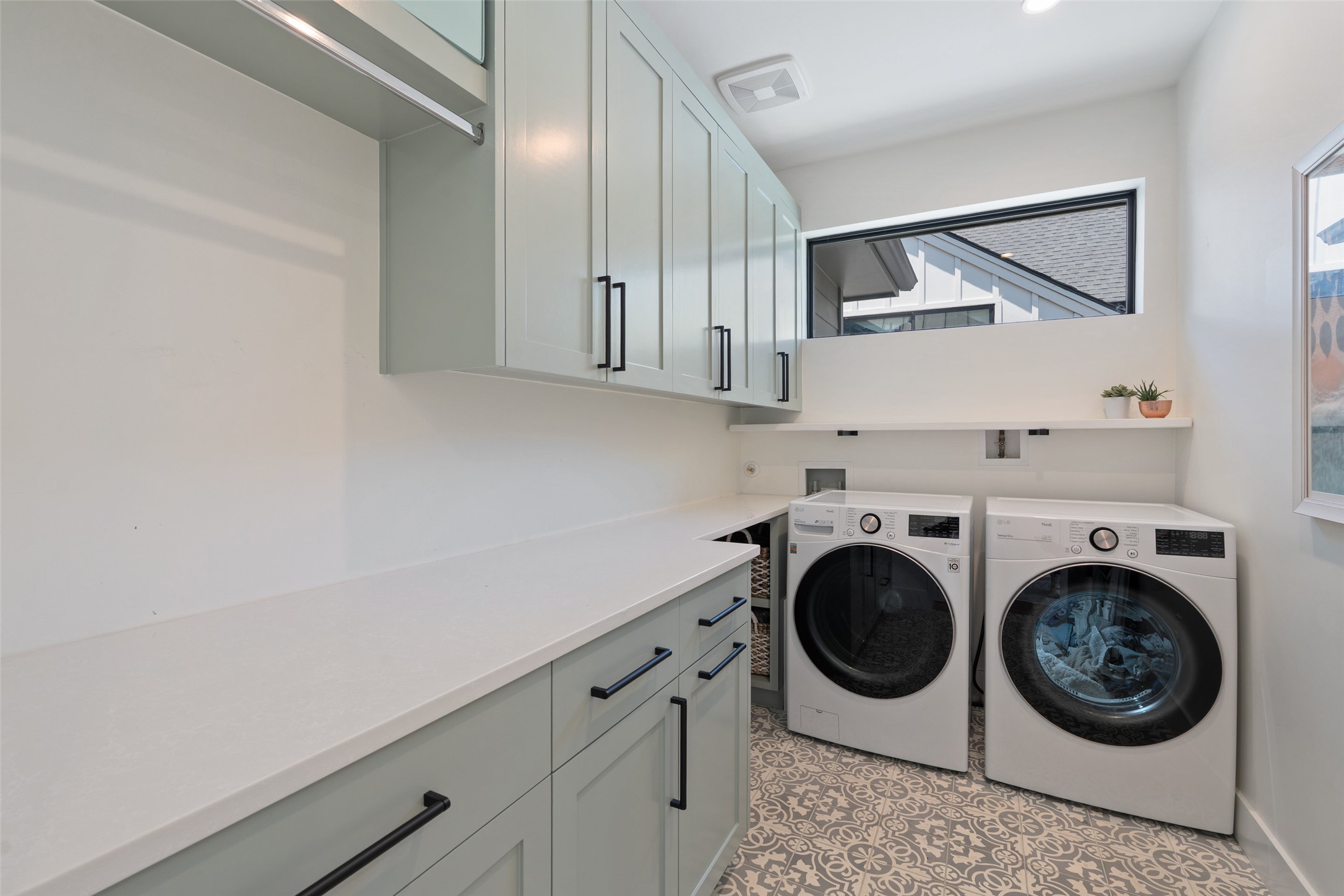 2107 Peach Tree Street Austin, TX 78704 - Photo 29 of 40 Clothes washing area featuring washing machine and dryer, cabinet space, plenty of natural light, and light tile patterned floors