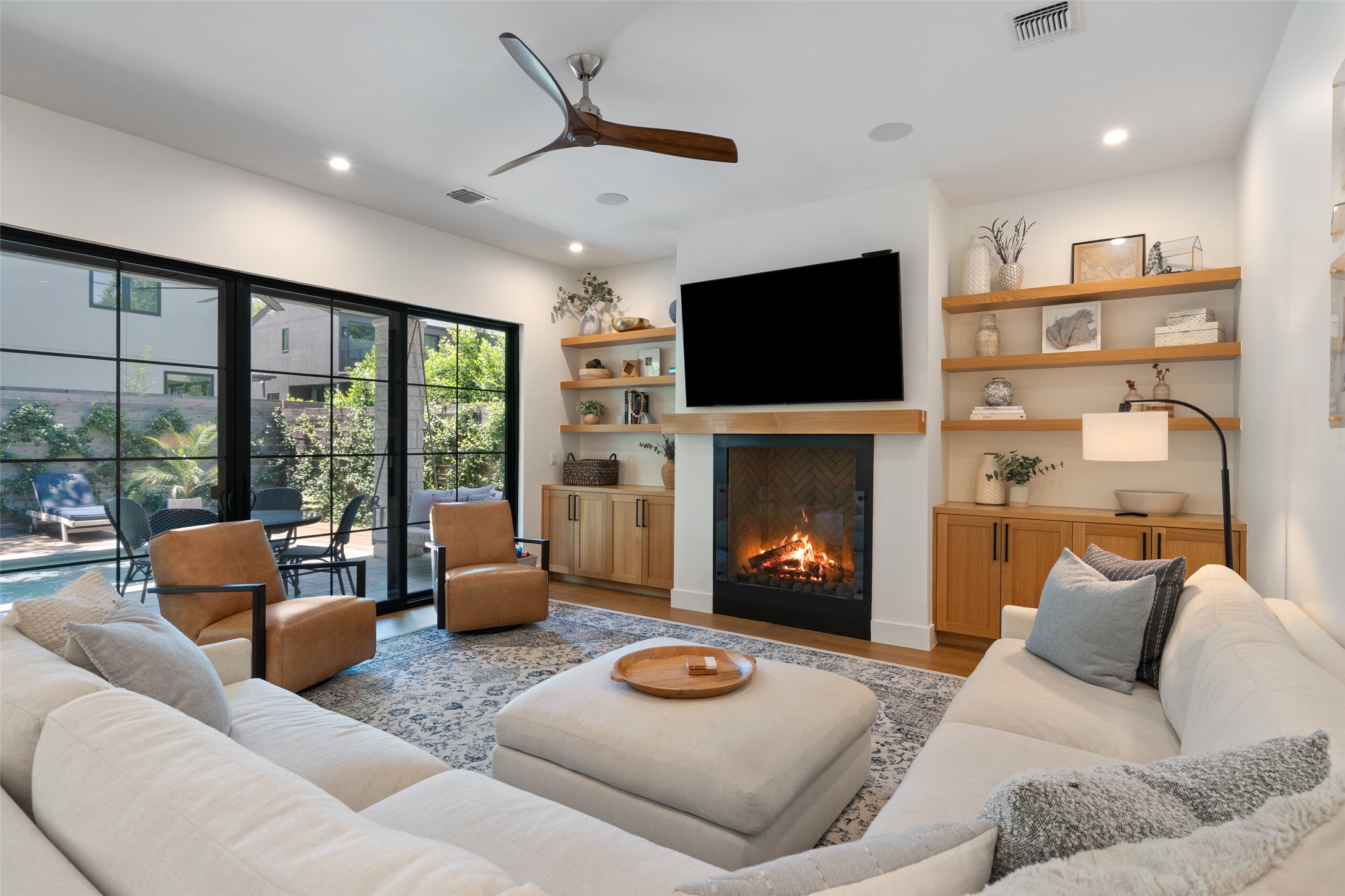 2107 Peach Tree Street Austin, TX 78704 - Photo 3 of 40 Living room featuring wood finished floors, ceiling fan, a glass covered fireplace, and recessed lighting