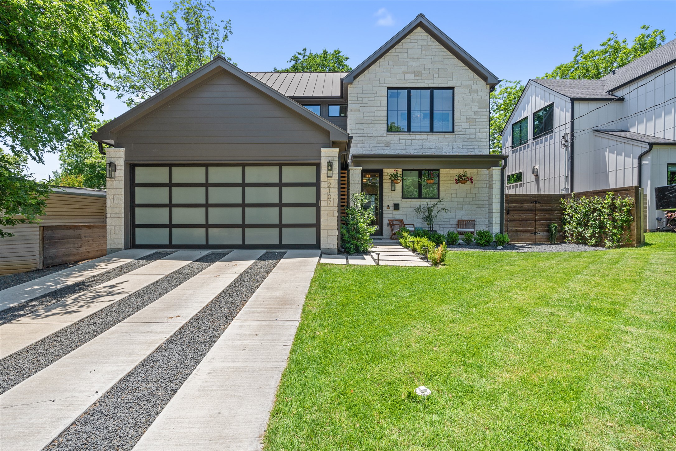 2107 Peach Tree Street Austin, TX 78704 - Photo 40 of 40 Contemporary house featuring a garage, driveway, a standing seam roof, metal roof, and stone siding