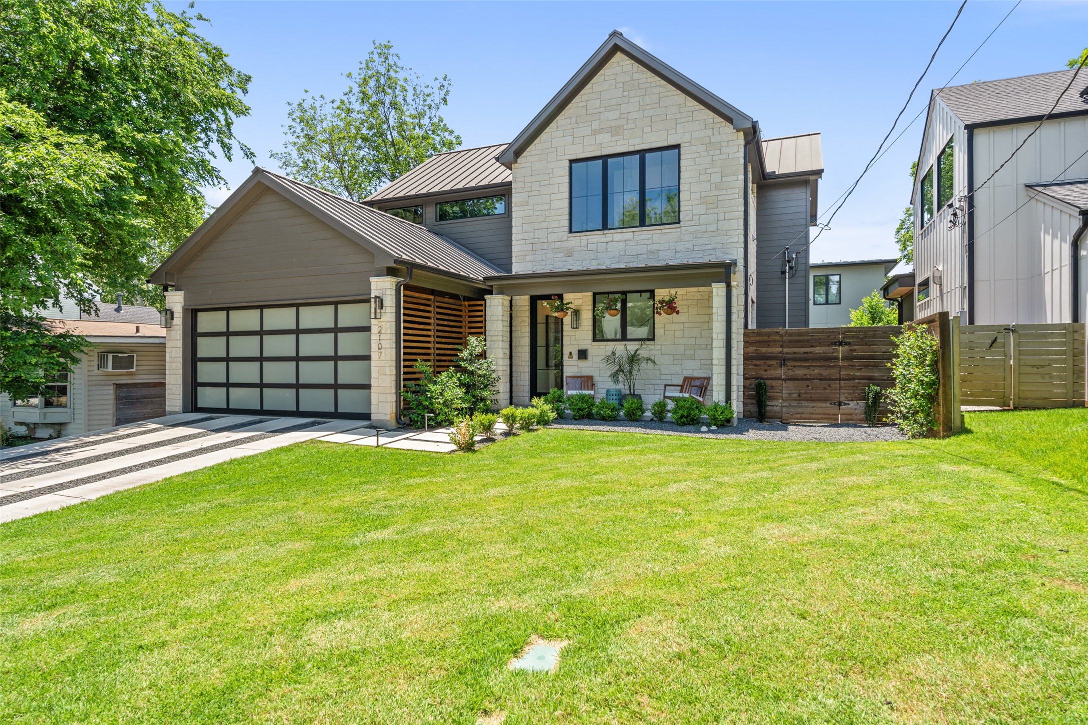 2107 Peach Tree Street Austin, TX 78704 - Photo 5 of 40 Contemporary home with a standing seam roof, an attached garage, driveway, metal roof, and stone siding