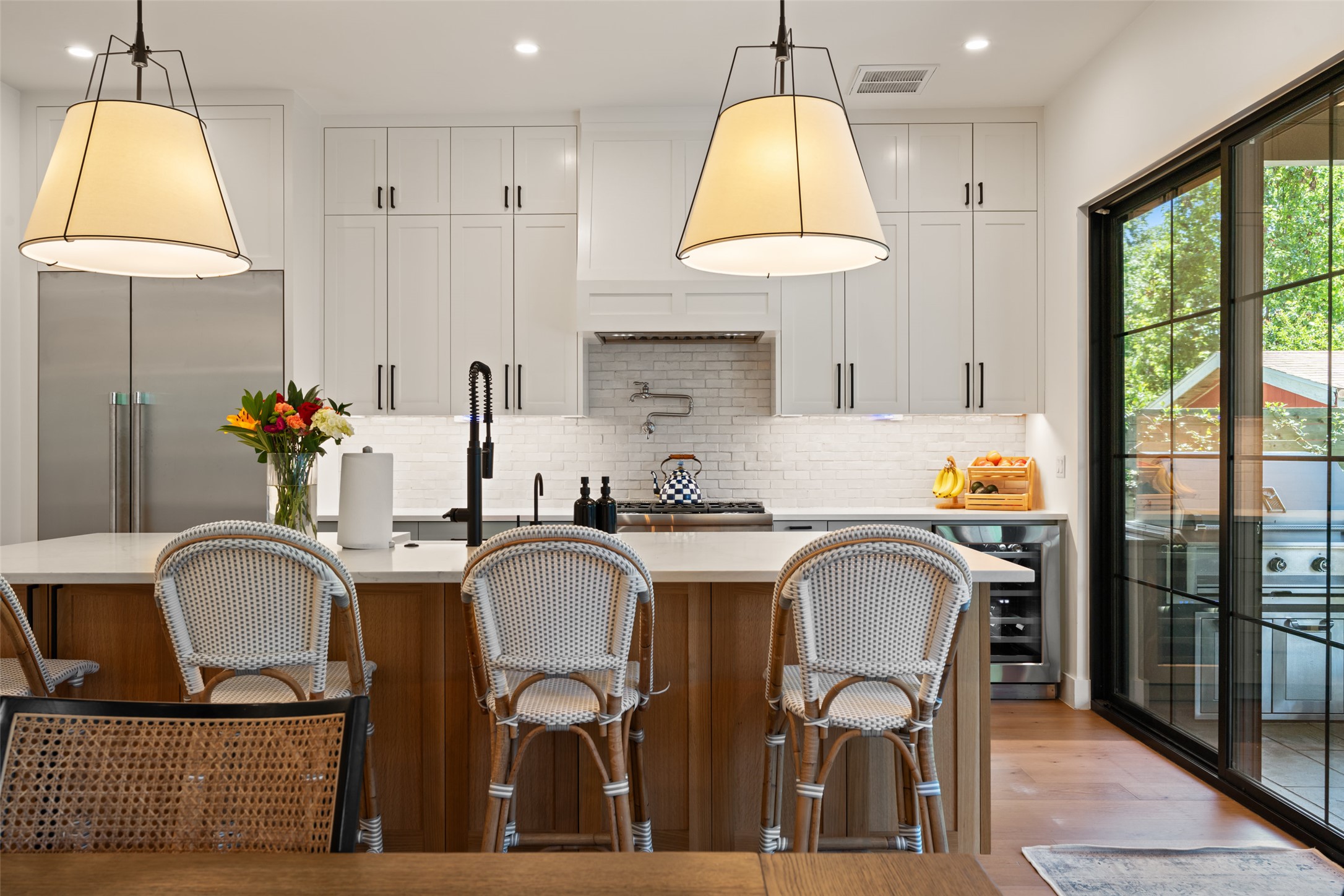 2107 Peach Tree Street Austin, TX 78704 - Photo 9 of 40 Kitchen with light countertops, beverage cooler, backsplash, high quality fridge, and a kitchen island with sink