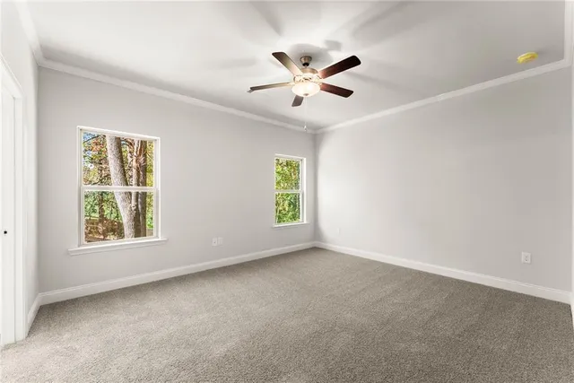 an empty room with windows and fan