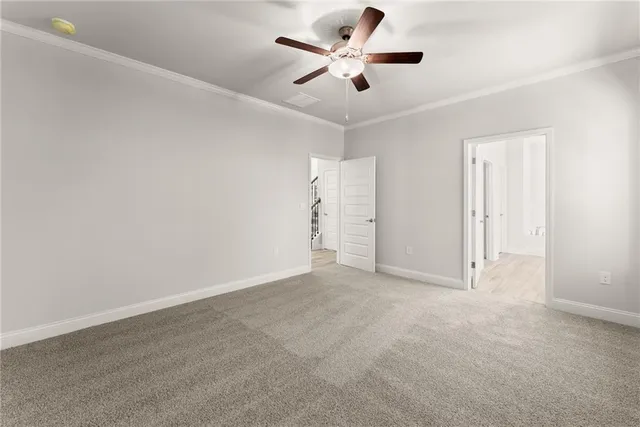an empty room with closet and a ceiling fan