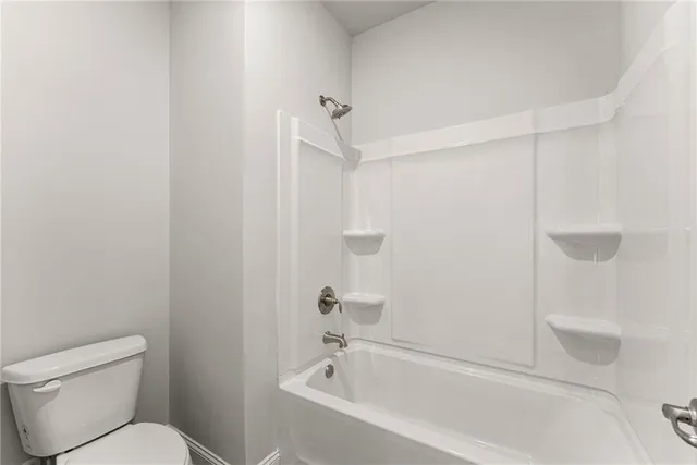 a white bath tub sitting next to a toilet