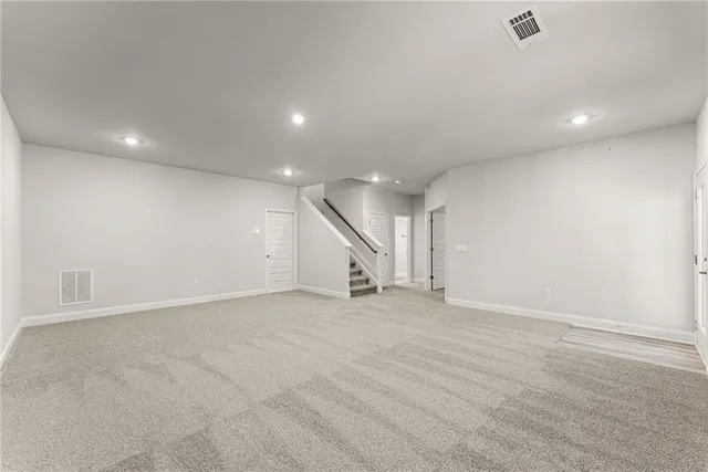 an empty room with stairs and white walls