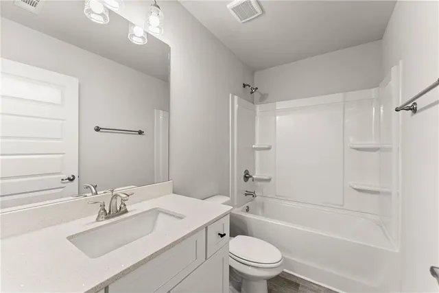 a bathroom with a bathtub shower sink vanity mirror and toilet