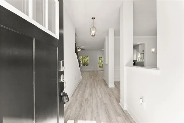 a view of a hallway with wooden floor and staircase