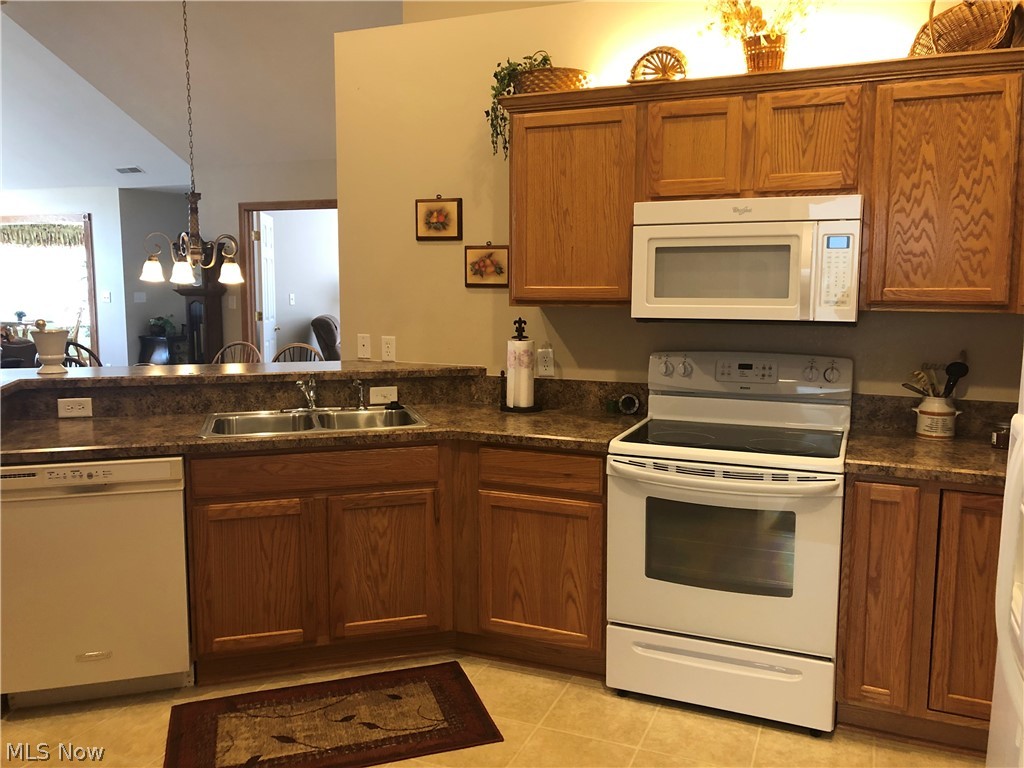 9151 Springfield Road, Unit 901 Youngstown, OH 44514 - Photo 12 of 18 Gourmet kitchen with vaulted ceilings, indirect lighting, dishwasher, range, refrigerator, microwave, and plenty of cabinets.