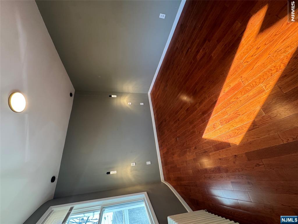 307 Henry Street, Unit 2 Fairview, NJ 07022 - Photo 5 of 10 a view of an empty room and wooden floor