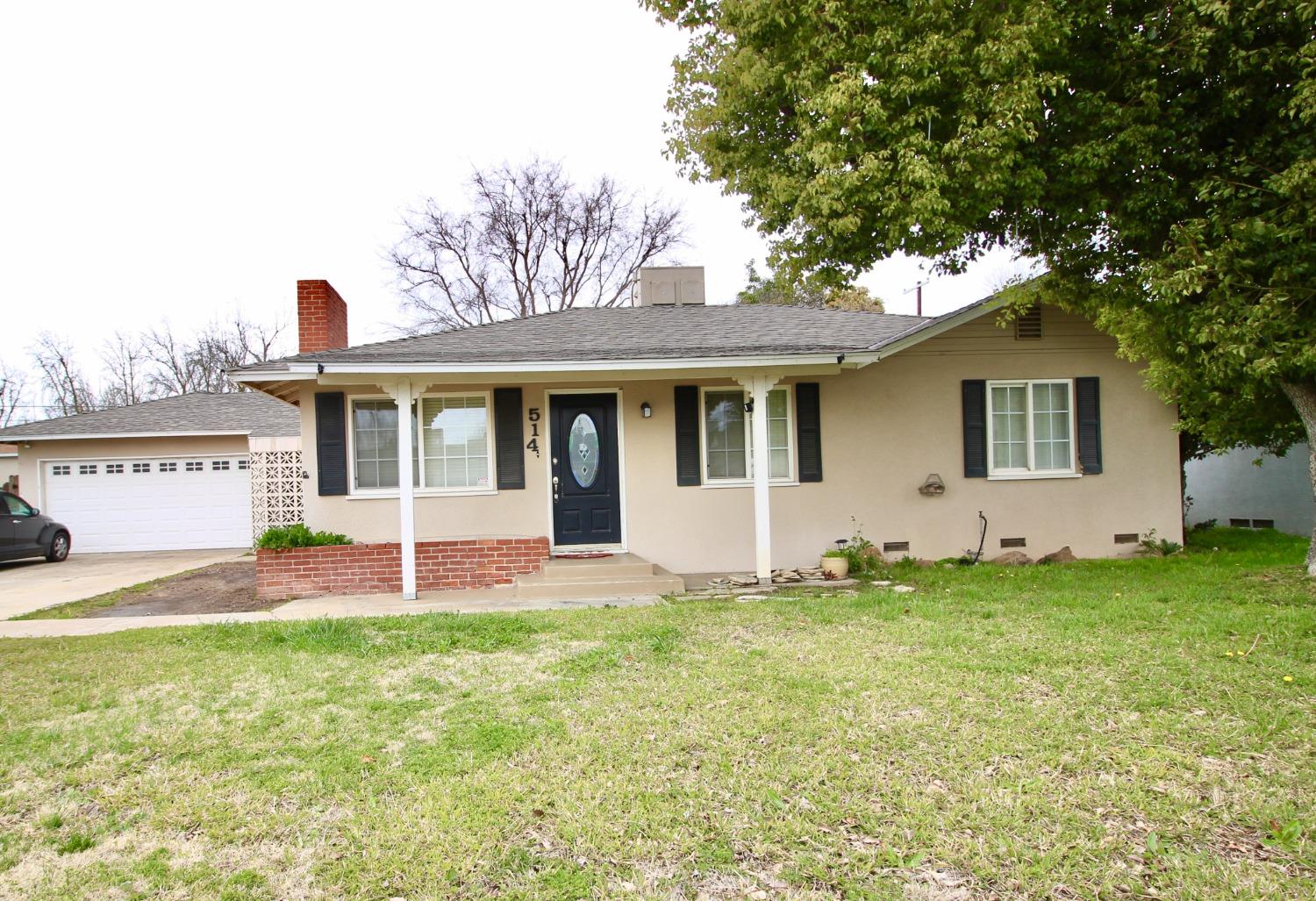 a view of a house with a yard and a tree