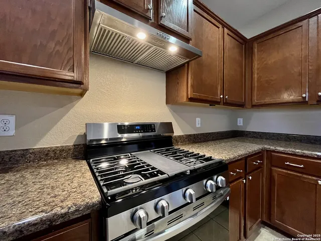 a kitchen with stainless steel appliances a refrigerator and a stove top oven