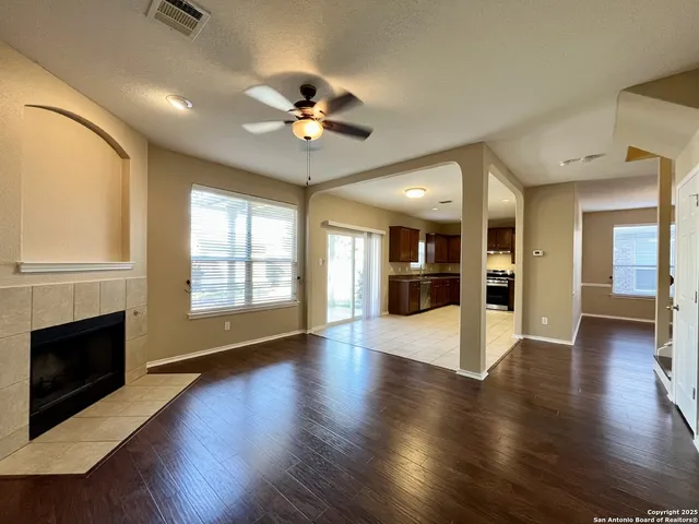 a view of a hallway with wooden floor and windows