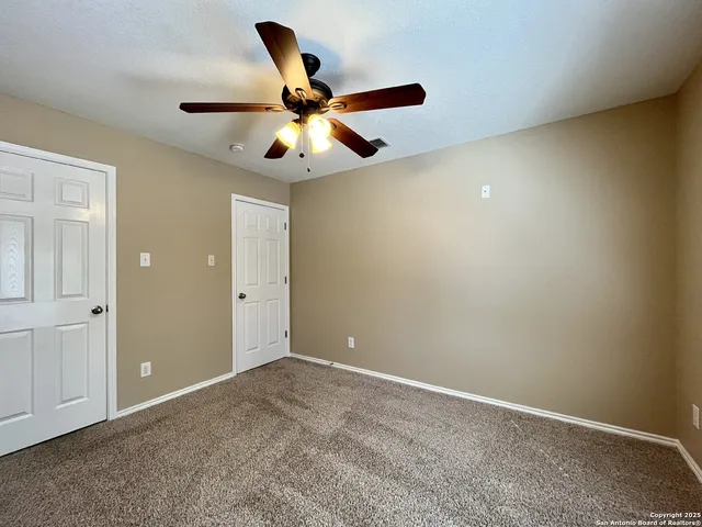 a view of a livingroom with a ceiling fan and window