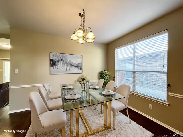 a view of a dining room with furniture a chandelier and wooden floor