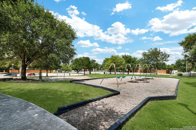 a view of a park with a bench and floor to ceiling window