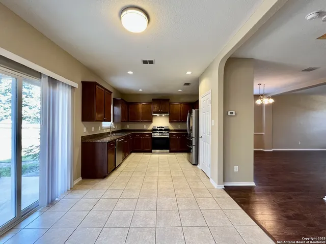 a kitchen with stainless steel appliances granite countertop a stove top oven a sink dishwasher a refrigerator and a microwave